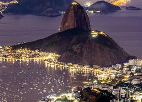 Breathtaking nighttime cityscape of Rio de Janeiro featuring Sugarloaf Mountain and Guanabara Bay.