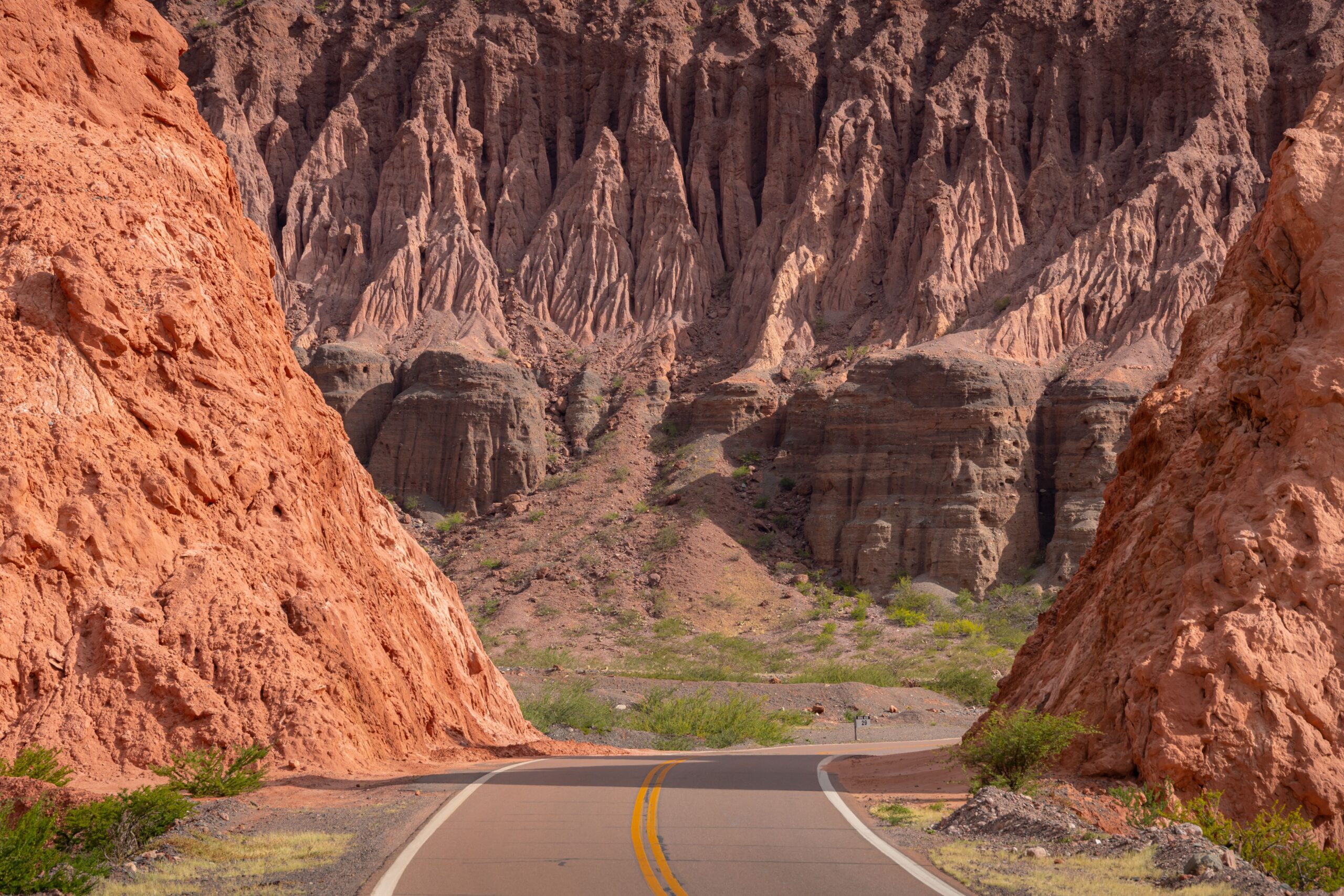 A picturesque road winds through stunning rock formations in Cafayate, Argentina, showcasing nature